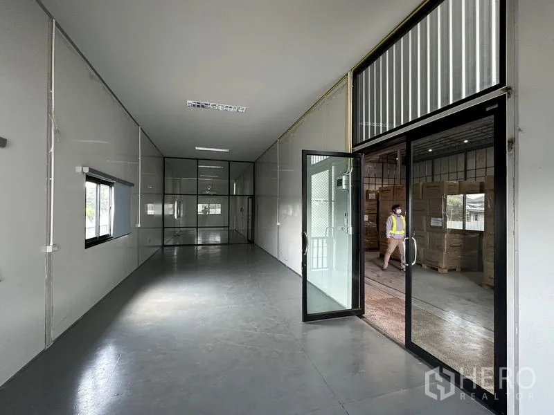 Warehouse for rent in Lat Krabang, Bangkok - Clean office area with glass partitions and sliding doors connected to the warehouse floor.