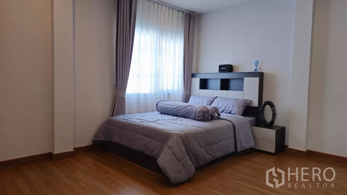 Detached House for rent or sale in Bang Phli, Samut Prakan - Second guest bedroom with grey bedding, bedside tables and a large curtained window.