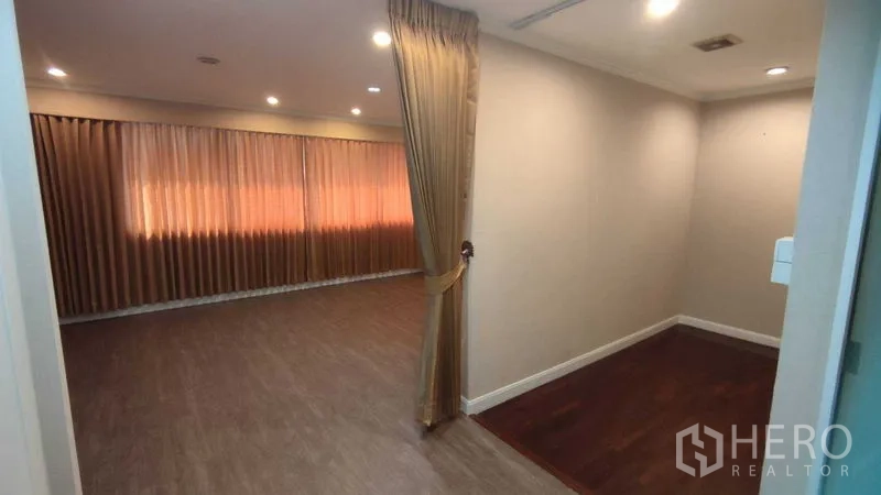 Home Office for rent in Watthana, Bangkok - Large flexible room with wood-look flooring, curtain divider and recessed lights.
