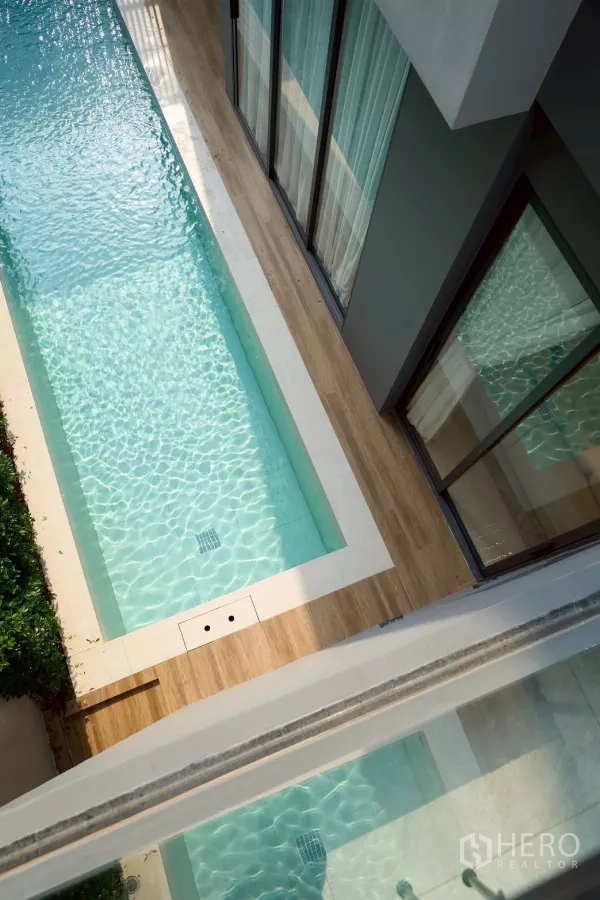 บ้าน ขายในLat Phrao, Bangkok - สระว่ายน้ำแบบแคบยาวข้างตัวบ้าน พร้อมพื้นทางเดินไม้และน้ําใส