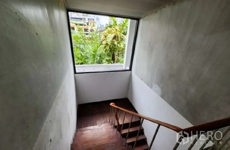 พื้นที่ขายปลีก ให้เช่าในWatthana, Bangkok - ช่องบันไดมีหน้าต่างมองเห็นต้นไม้เขียวขจีและอาคารรอบข้าง