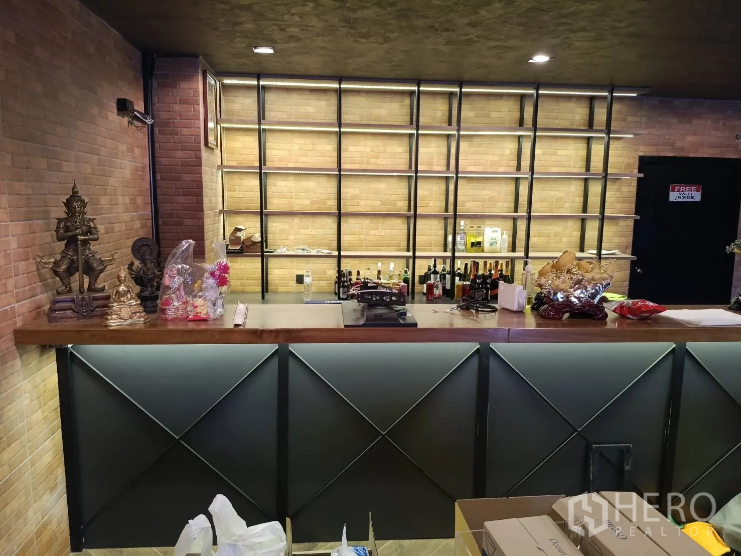 Retail Space for rent - Bar counter with decorative statues and tall illuminated shelving behind.