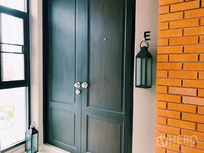 คอนโด ให้เช่าในWatthana, Bangkok - ประตูทางเข้าคู่สีเข้ม มีโคมไฟแขวนข้างผนังอิฐ