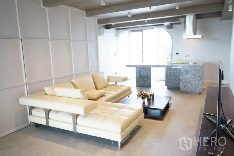 คอนโด ให้เช่าหรือขายในBang Na, Bangkok - มุมมองอีกด้านของโซนนั่งเล่นโอเพนแพลนกับโซฟาสีขาวและไอแลนด์หินแกรนิต