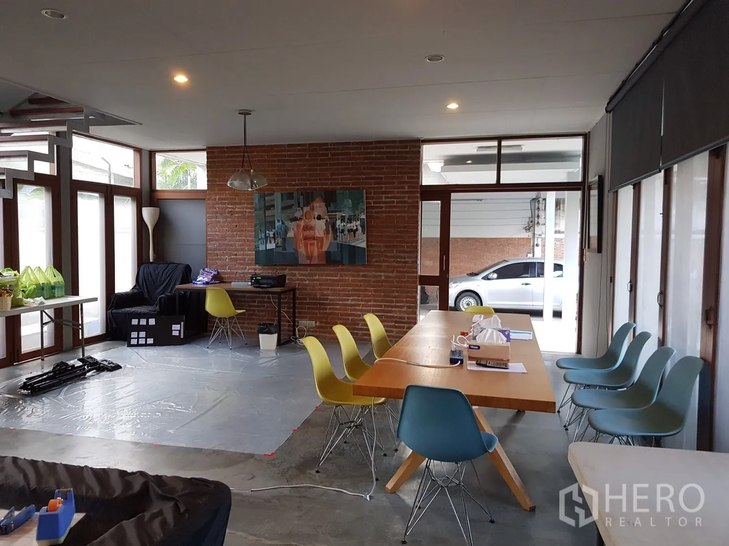 Home Office for rent in Watthana, Bangkok - Collaborative open space with long table, brick feature wall and wide windows.