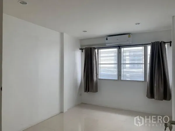 ทาวน์เฮาส์ ให้เช่าในDin Daeng, Bangkok - ห้องนอนโปร่งสามหน้าต่าง ม่าน และเครื่องปรับอากาศติดผนัง