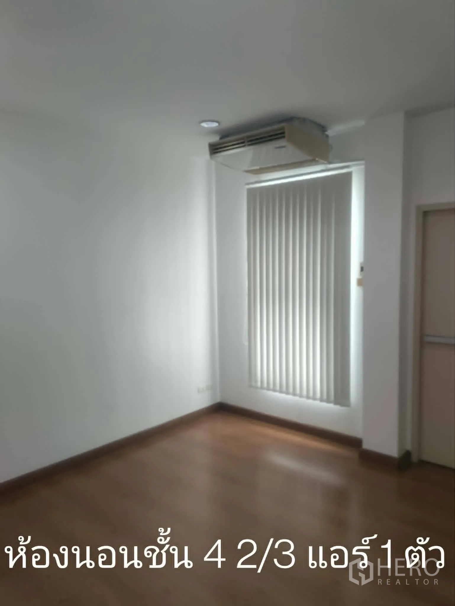 Home Office for rent in Lat Phrao, Bangkok - Corner bedroom with wood floors, vertical blinds, and ceiling air conditioner.