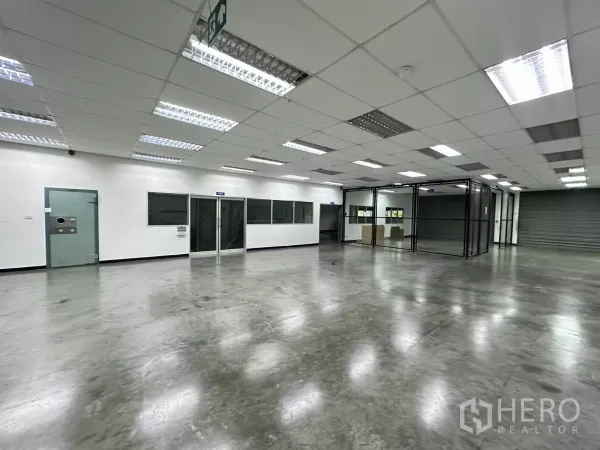 โรงงาน ขายในLat Krabang, Bangkok - โถงทำงานพร้อมผนังกระจก ป้ายทางหนีไฟ และประตูม้วน