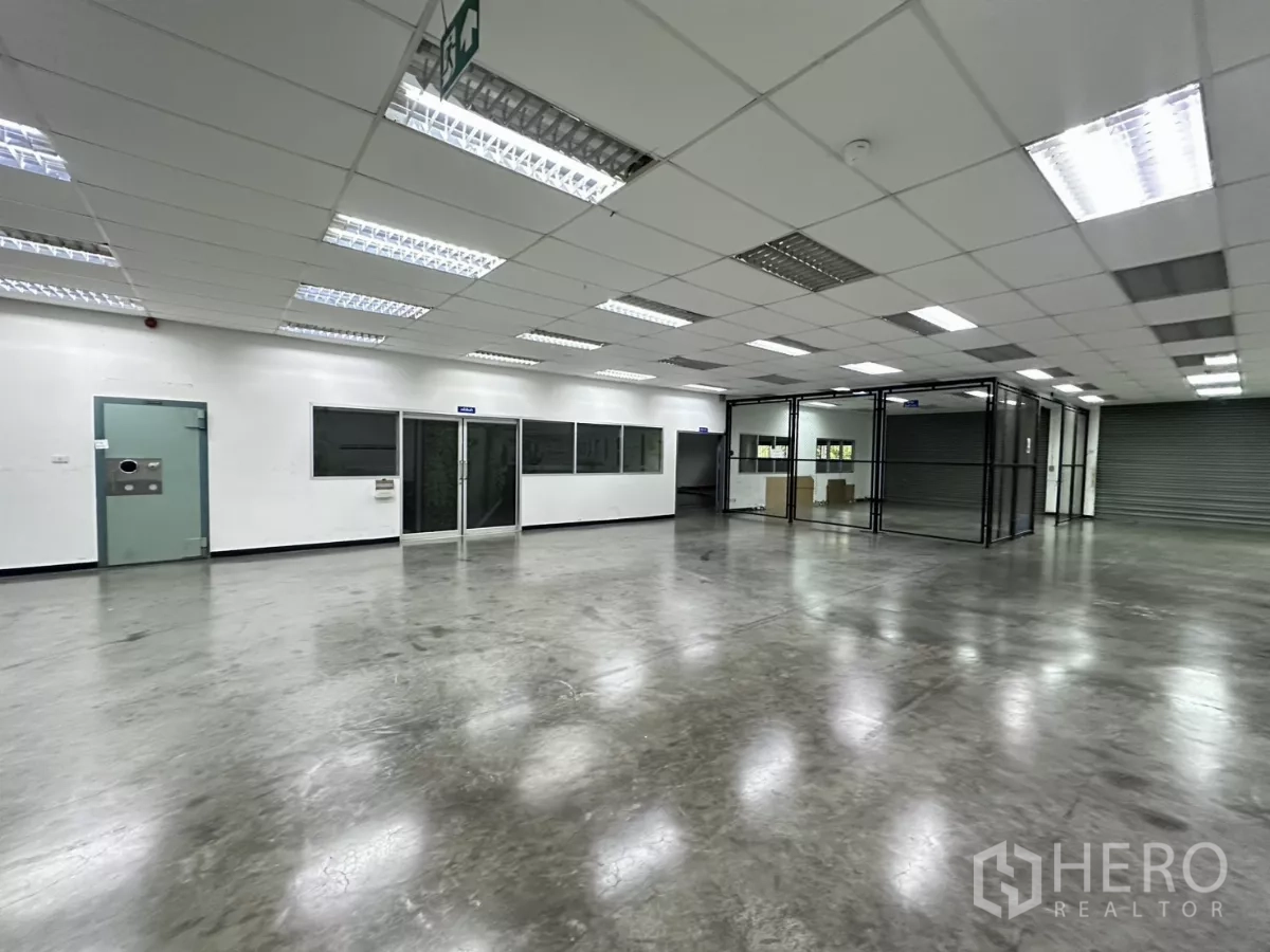 โรงงาน ขายในLat Krabang, Bangkok - โถงทำงานพร้อมผนังกระจก ป้ายทางหนีไฟ และประตูม้วน