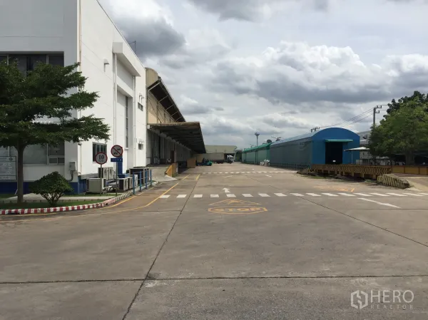 货栈 出租在Pathum Thani - 位于巴吞他尼的工业仓库园区，带遮蔽装卸月台与宽阔混凝土车道，卡车出入便捷。