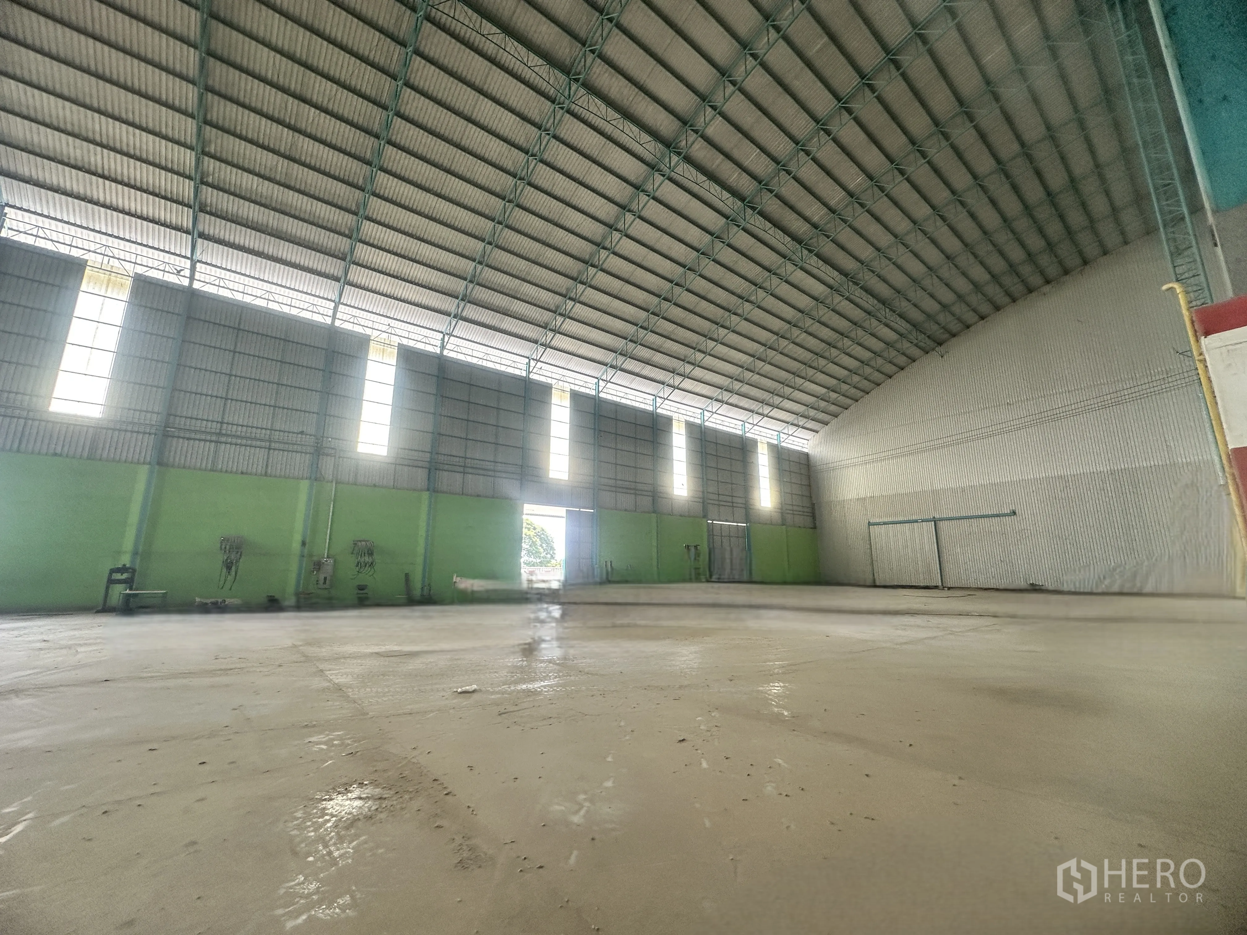 仓库 for rent in Sai Noi, Nonthaburi - 仓库大厅，高屋顶、混凝土地坪与多处大型出入口。