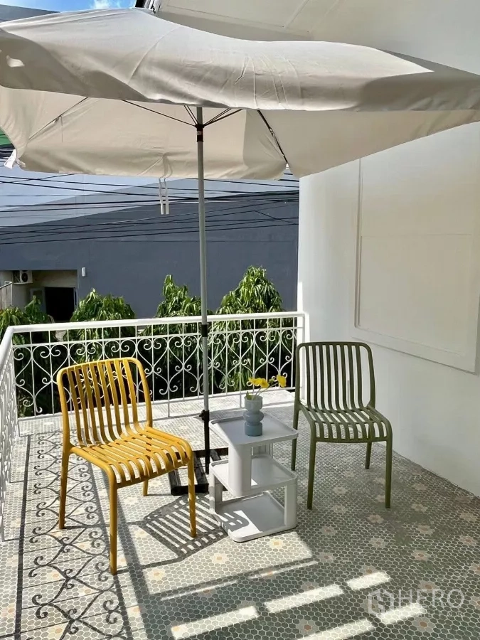 Detached House for rent in Chatuchak, Bangkok - Balcony terrace with patterned tiles, railing, umbrella and outdoor chairs.