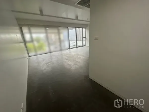 สำนักงาน ให้เช่า - โถงทางเข้าเปิดสู่พื้นที่ทำงานแบบเปิดโล่ง มีหน้าต่างบานใหญ่และพื้นกระเบื้องสีเข้ม