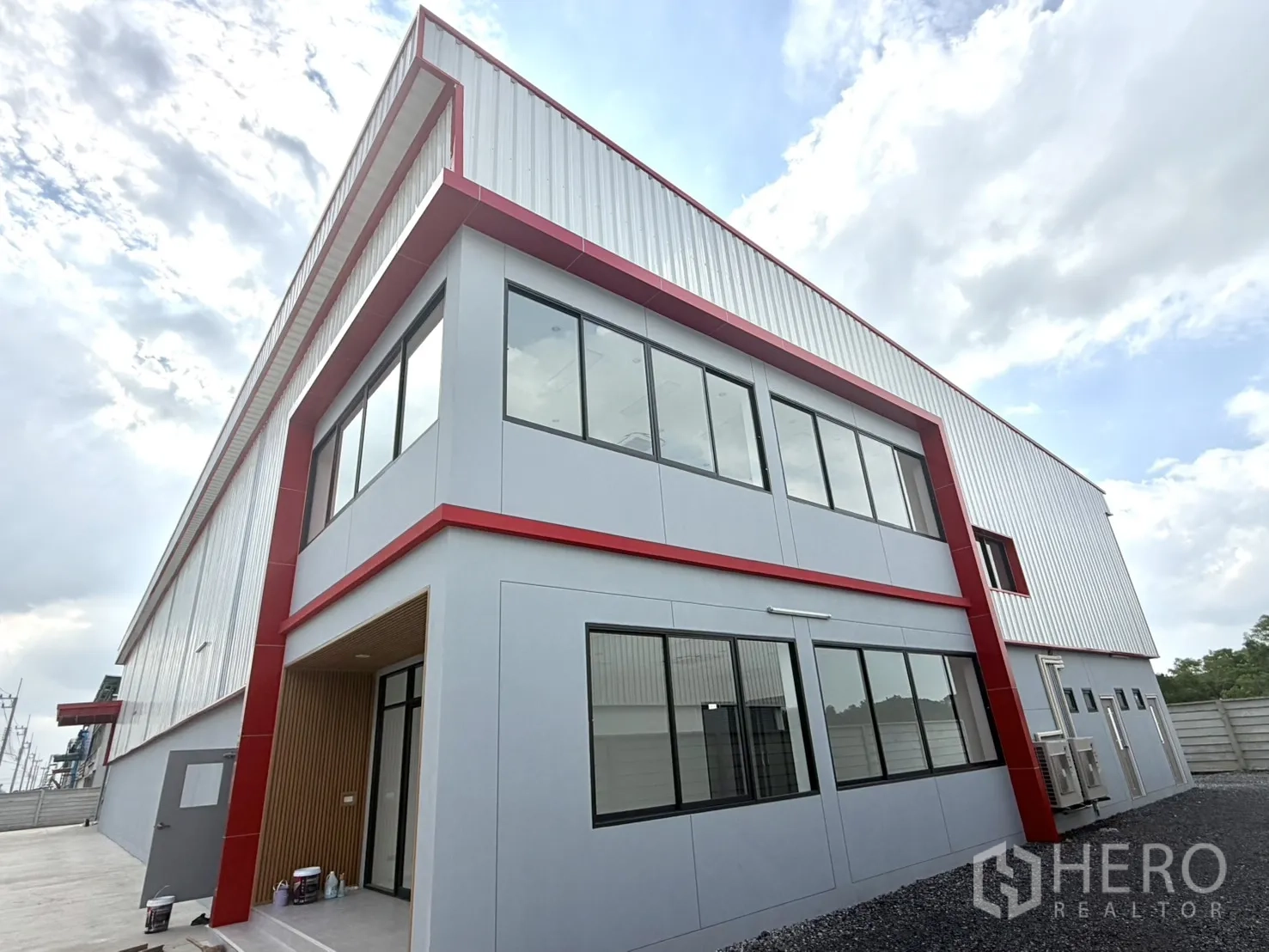 Factory for rent or sale in Lam Luk Ka, Pathum Thani - Close-up of the office exterior showing large windows and red trim.