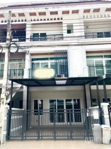 ทาวน์เฮาส์ ให้เช่าในPrawet, Bangkok - ภาพแสดงด้านหน้าทาวน์เฮ้าส์ 3 ชั้นในประเวศ มีที่จอดรถในรั้วและระเบียง.