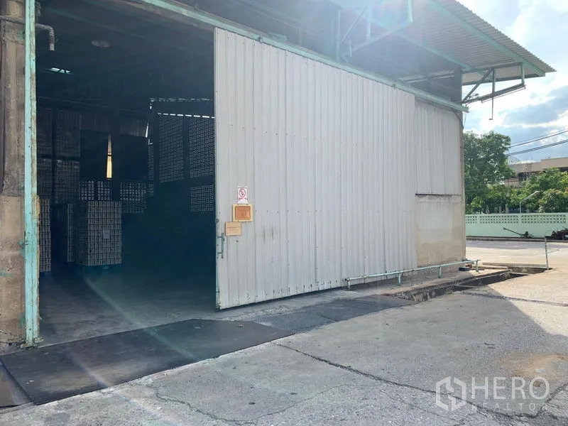 货栈 出租在Mueang Pathum Thani, Pathum Thani - 带雨棚的装卸区，配大尺寸推拉门与车道出入口。