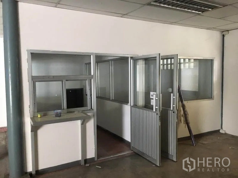 货栈 出租在Prawet, Bangkok - 仓库底层的隔断办公室，带玻璃窗与金属门。
