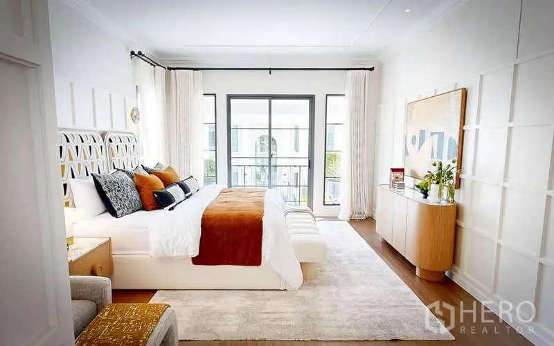 Detached House for rent in Bang Phli, Samut Prakan - Facade of Setthasiri Bangna detached house with balcony, covered parking and trimmed hedges along a quiet street.