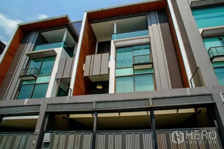 ทาวน์เฮาส์ ให้เช่าหรือขายในWatthana, Bangkok - ด้านหน้าอาคารทาวน์เฮ้าส์สไตล์โมเดิร์น มีระเบียงกระจกและที่จอดรถในร่ม