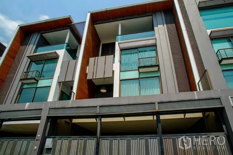 ทาวน์เฮาส์ ให้เช่าหรือขายในWatthana, Bangkok - ด้านหน้าอาคารทาวน์เฮ้าส์สไตล์โมเดิร์น มีระเบียงกระจกและที่จอดรถในร่ม