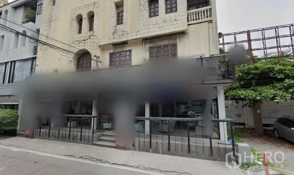 零售空间 出租在Watthana, Bangkok - 街景外观：低层建筑，抬高露台与通透玻璃店铺。