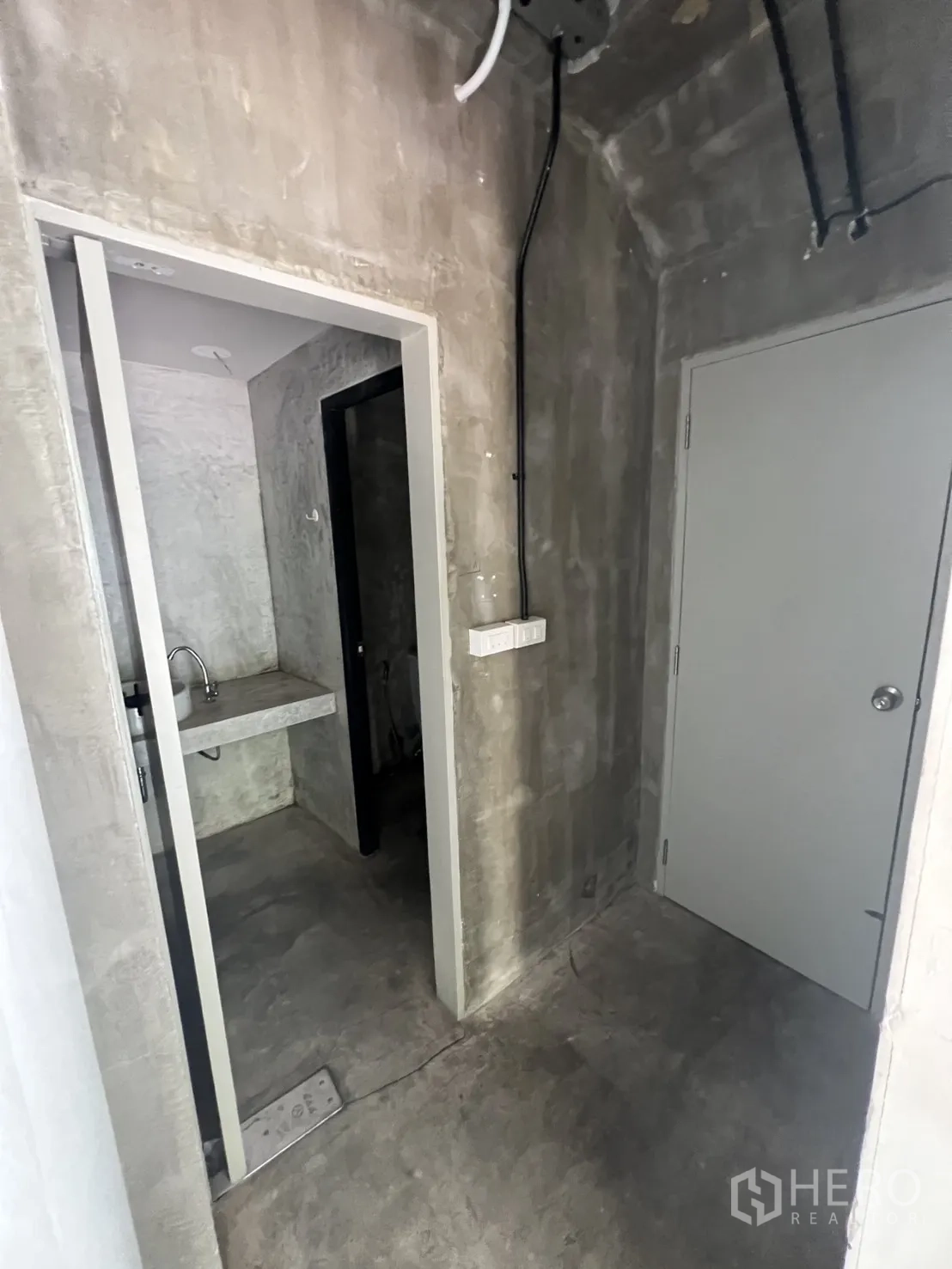 店屋 出租在Watthana, Bangkok - 服务走廊，清水混凝土质感并设小洗手池。