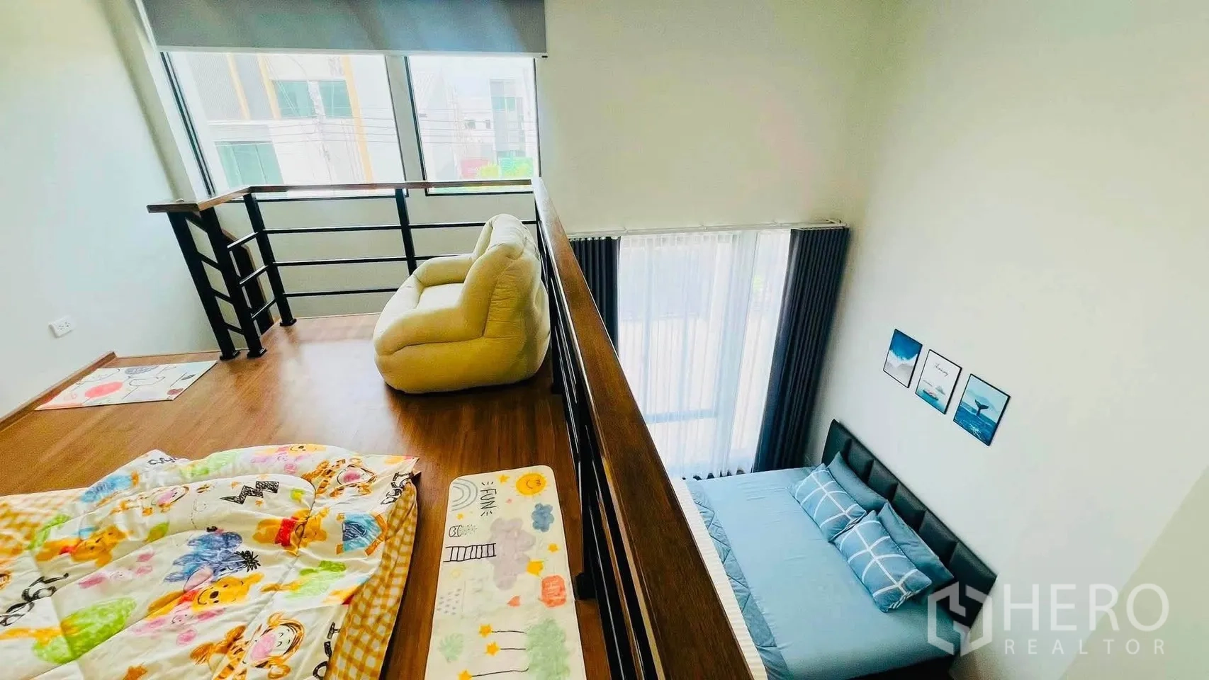 ทาวน์เฮาส์ for rent in Bang Phli, Samut Prakan - มุมมองจากชั้นลอยลงสู่ห้องนอนเพดานสูง พร้อมราวกันตกและเก้าอี้บีนแบ็ก