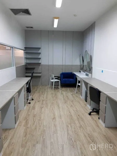 สำนักงาน ให้เช่าในKhlong Toei, Bangkok - ห้องทำงานทรงลึกพร้อมโต๊ะบิวท์อิน กระจกเงา ชั้นวาง และเก้าอี้โซฟาสีน้ำเงิน