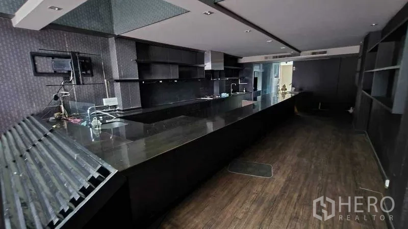 店屋 出租在Khlong Toei, Bangkok - 深色石材长吧台与开放式置物架和服务区，适合餐厅或咖啡馆。