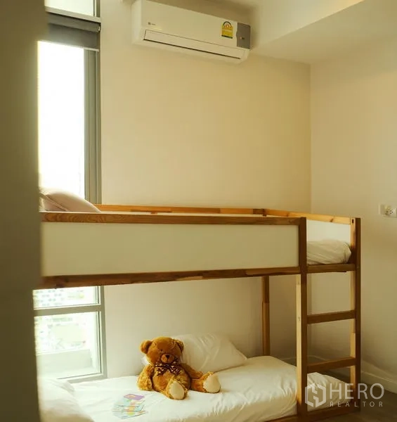 公寓 出租在Bang Rak, Bangkok - 紧凑卧室，木质上下铺靠近高窗，墙上装空调