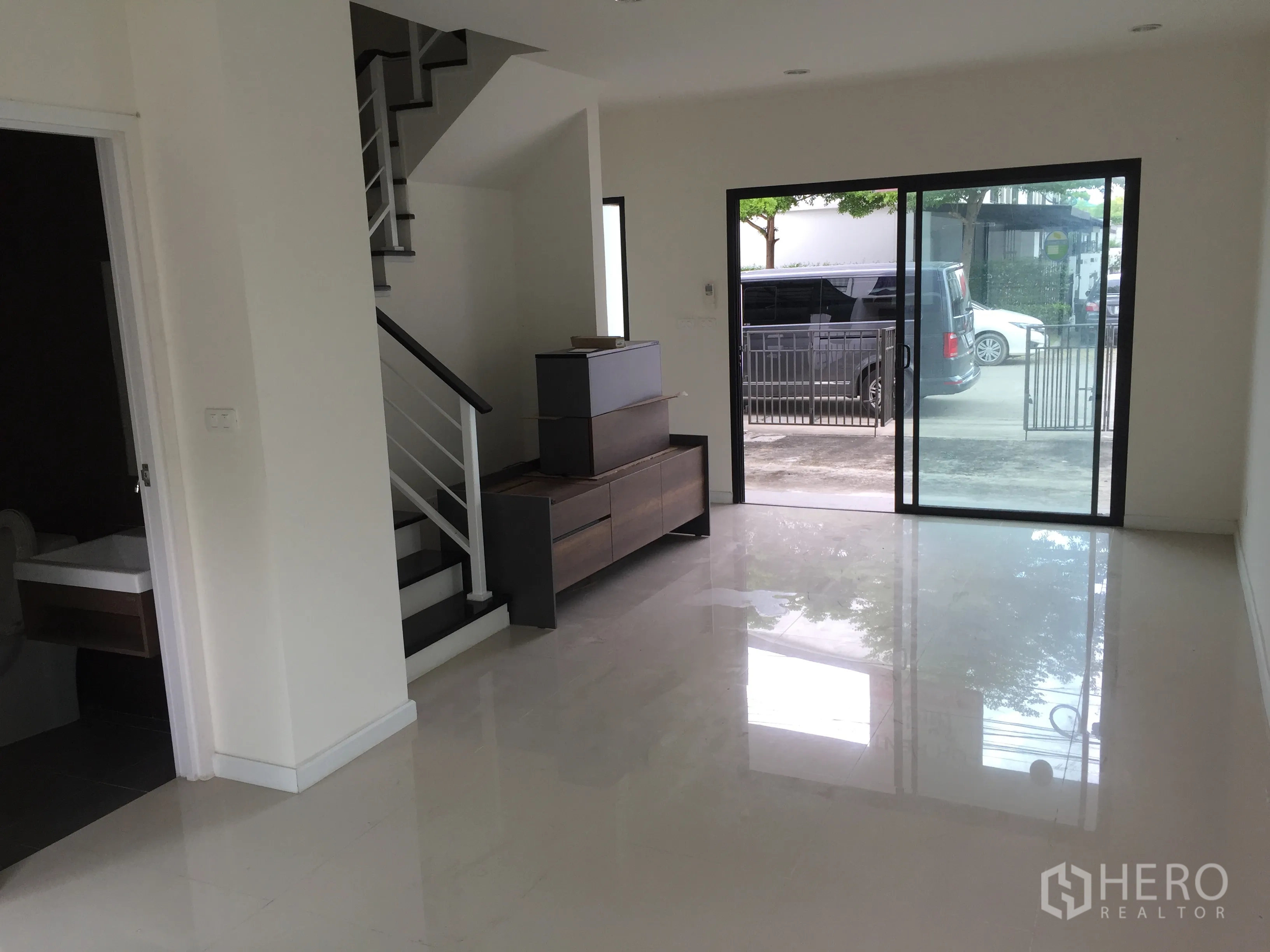 Townhouse for rent in Bang Kapi, Bangkok - Open-plan living and dining space with staircase, guest bathroom and front sliding door.