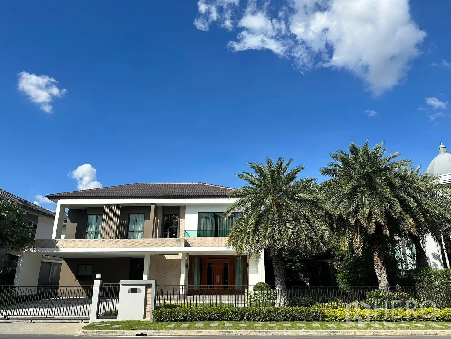 บ้าน ให้เช่าในPrawet, Bangkok - ด้านหน้าบ้านสองชั้นสมัยใหม่ มีต้นปาล์ม สวนหน้าบ้าน และที่จอดรถ เขตประเวศ