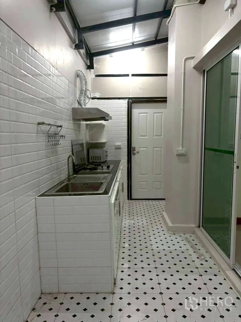 ทาวน์เฮาส์ for rent in Suan Luang, Bangkok - ห้องครัวปิดพร้อมเตาแก๊ส เครื่องดูดควัน อ่างล้าง และผนังกระเบื้องลายอิฐขาว