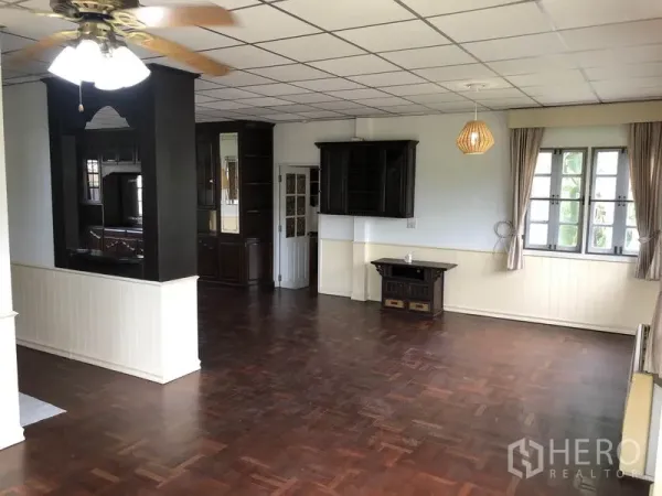 独立式住宅 出租 - 宽敞客厅，吊扇、木地板与多扇窗户。