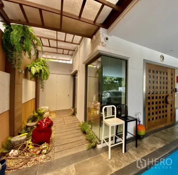 Home Office for rent or sale in Yan Nawa, Bangkok - Covered entry corridor with skylight roof, wood walkway, and small garden beside a glass corner.
