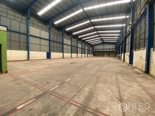 Warehouse for rent in Lat Lum Kaeo, Pathum Thani - Open column-free storage hall with ventilated metal cladding and bright skylight panels.