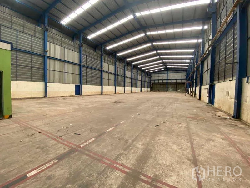 Warehouse for rent in Lat Lum Kaeo, Pathum Thani - Open column-free storage hall with ventilated metal cladding and bright skylight panels.