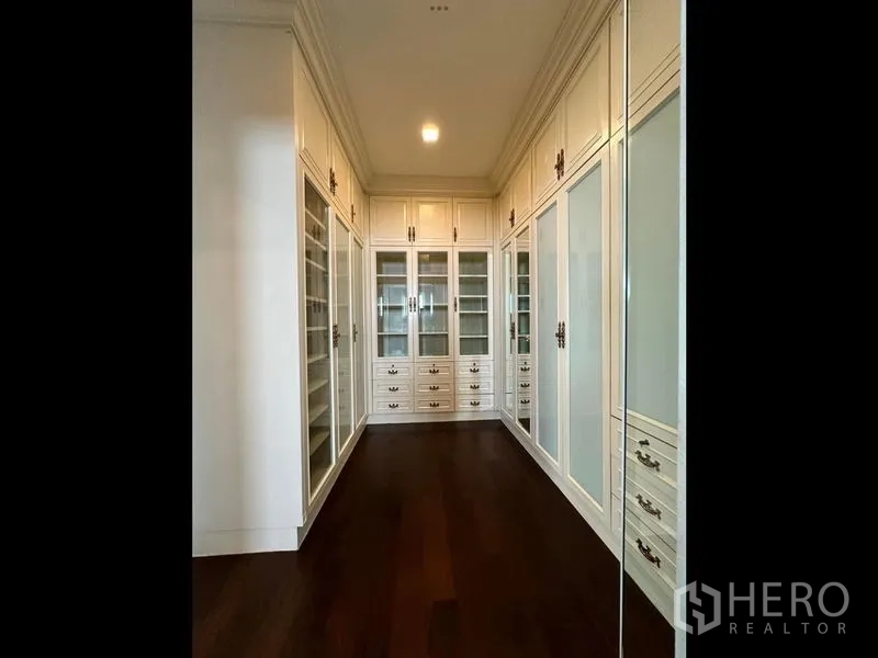Detached House for rent or sale - Walk-in closet corridor lined with white glass-front cabinetry and dark wood flooring.
