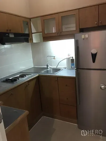 คอนโด ให้เช่าในWatthana, Bangkok - ครัวรูปตัวแอลตู้ไม้ มีเตา เครื่องดูดควัน อ่างล้างจานคู่ และตู้เย็นสแตนเลส