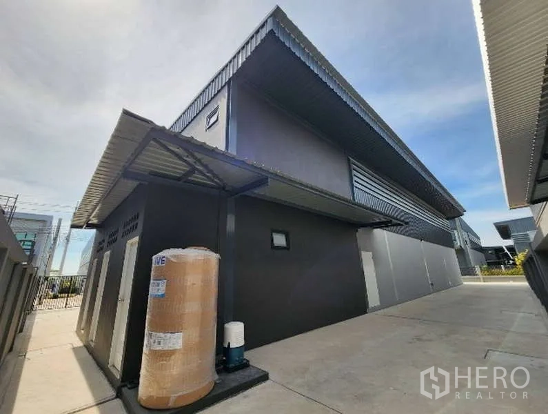 Factory for rent in Bang Bo, Samut Prakan - Modern factory exterior with metal cladding, side walkway and water tank