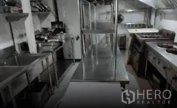 零售空间 出租在Watthana, Bangkok - 不锈钢商用厨房，带排烟罩、洗槽与燃气灶。