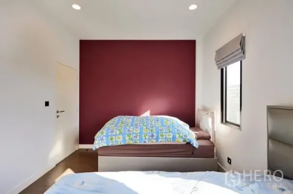 独立式住宅 出租或出售在Bang Kapi, Bangkok - 温馨次卧，酒红色强调墙，配侧窗与木地板。