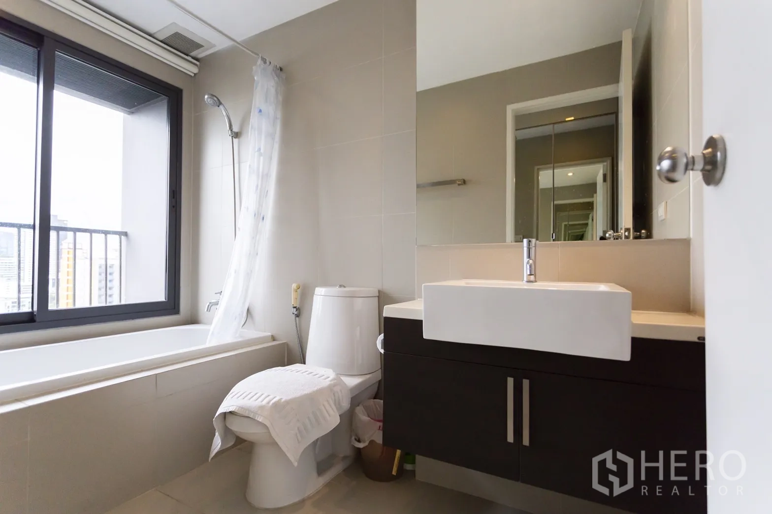 公寓 出租在Khlong Toei, Bangkok - 现代浴室，靠窗浴缸、坐便和方形台上盆洗手台。