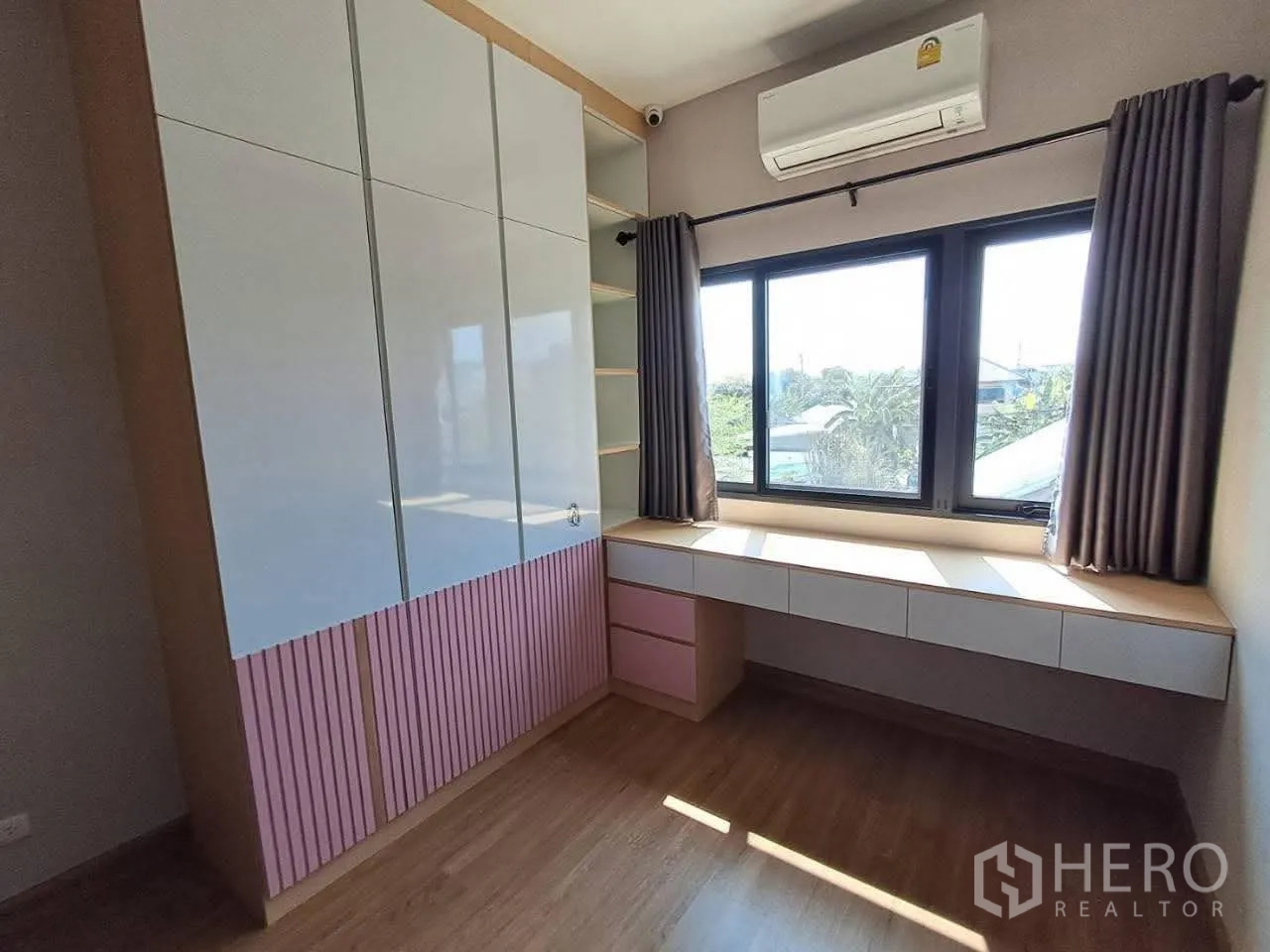 联排别墅 for rent in Bang Kapi, Bangkok - 卧室配嵌入式衣柜、窗下长书桌与空调。