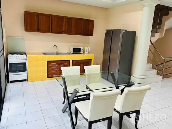 Home Office for rent - Open kitchen with yellow tile counter, wooden cabinets, glass dining table and large fridge.