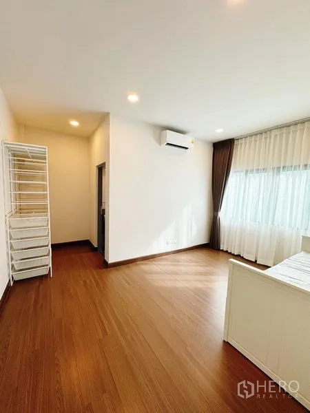 Detached House for rent in Bang Phli, Samut Prakan - Large bedroom with air conditioning, ensuite access and wood floors.