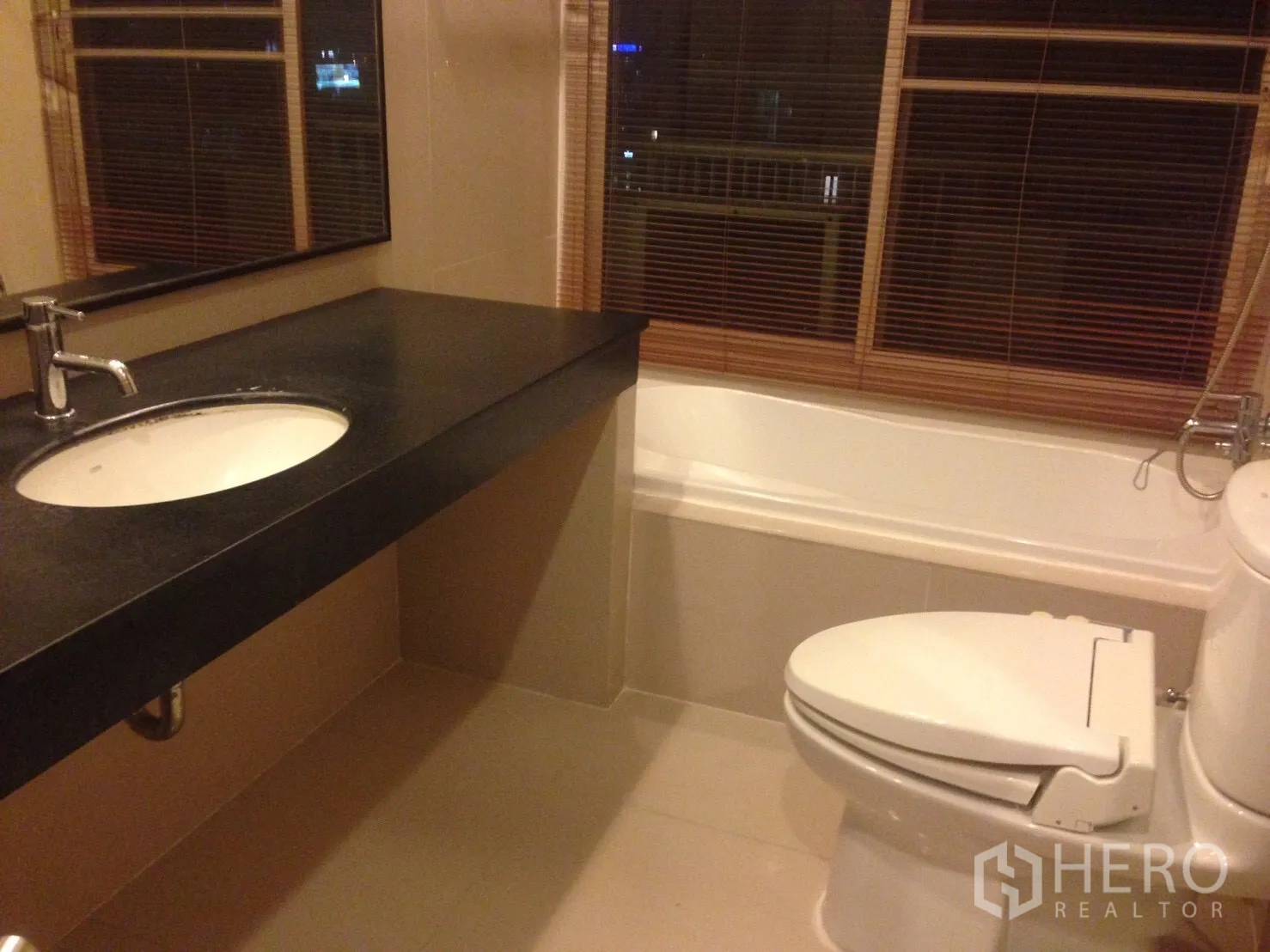 คอนโด ให้เช่าในWatthana, Bangkok - ห้องน้ำเคาน์เตอร์ยาว อ่างล้างหน้า อ่างอาบน้ำพร้อมมู่ลี่ และโถสุขภัณฑ์โทนสีอบอุ่น