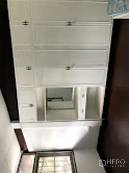 Detached House for rent in Suan Luang, Bangkok - Built-in white cabinetry with countertop and sink beside a window.