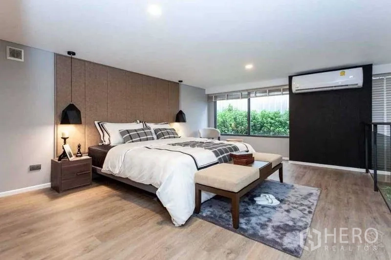 Condominium for sale in Huai Khwang, Bangkok - Staged master bedroom with king bed, pendant lights and wood flooring.