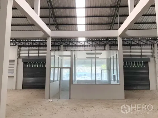 工厂 出租在Bang Bua Thong, Nonthaburi - 厂内中央玻璃隔断办公室，左右为卷帘门出入口。